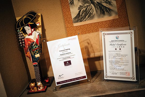 Halal certificates awarded by two different organizations stand on display in the Sushi Ken restaurant.