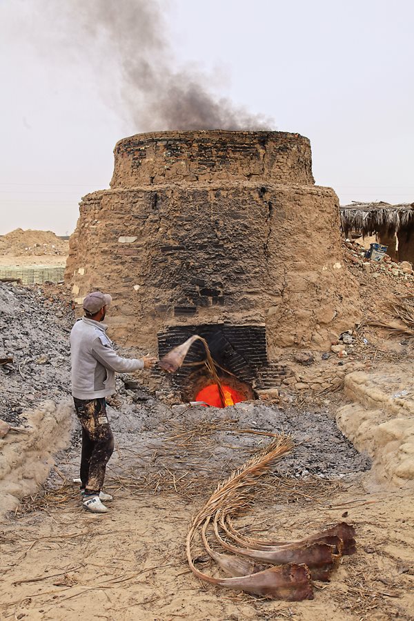 In the kiln the bricks are baked at almost 1,000 degrees Celsius. Nasri Chabani, <b>above and below</b>, uses fronds cut from the palmeraie as fuel. It takes around 6,000 of them to keep a kiln going for the 24 hours a load of 10,000 to 20,000 bricks requires. Afterward, the bricks cool for three or four days.&nbsp;